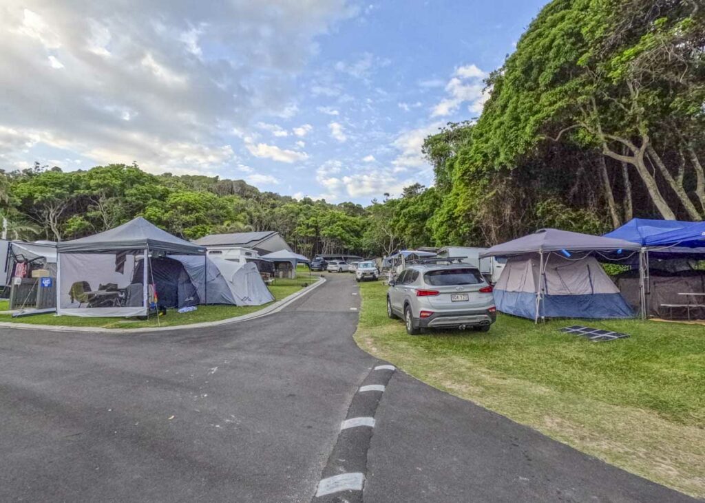 a road with campsites and tents at Broken Head Holiday Park